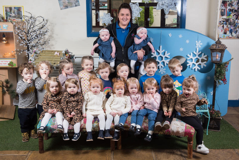 Erzieherin Steph Doxsey hält ihre Töchter Gracie und Lottie auf dem Arm, die fünf MOnate alt sind. Vor ihr in der hinteren Reihe: Tobias & Arlo McHugh, 2, Rey & Joanie Layton, 4, Chloe & Emily Worrall, 3, Archie & Ben Lowther, 4. Hintere Reihe: Elizabeth & Olivia Handby, 22 Monate, Penelope & Grace McMahon, 1, Sadie & Lottie Dean, 2, Sia & Ava Vivaldi, 2 (Bild: Mercury Press)