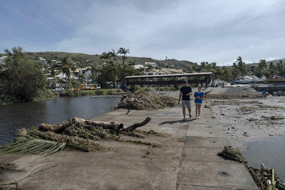 People walk on a dike to watch damages in the marina of Saint-Gilles les Bains on the French Indian Ocean island of Reunion, Tuesday, Jan. 16, 2024. Tropical cyclone Belal had battered the French island of Reunion, where the intense rains and powerful winds left about a quarter of households without electricity after hitting Monday morning, according to the prefecture of Reunion. (AP Photo/Lewis Joly)