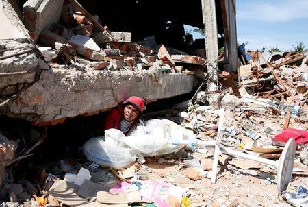 A man retrieves fans from a collapsed shop following a strong earthquake in Meureudu, Pidie Jaya, Aceh province, Indonesia December 8, 2016. REUTERS/Darren Whiteside