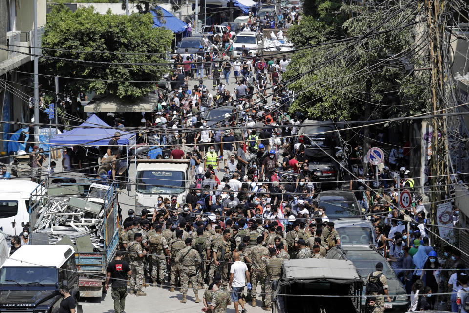 Lebanese soldiers block a road and scuffle with angry residents as French President Emmanuel Macron visits the Gemmayzeh neighborhood, which suffered extensive damage from the Tuesday explosion at the seaport of Beirut, in Beirut, Lebanon, Thursday, Aug. 6, 2020. Lebanese officials targeted in the investigation of the massive blast that tore through Beirut sought to shift blame for the presence of explosives at the city's port, and the visiting French president warned that without serious reforms the country would "continue to sink." (AP Photo/Hassan Ammar)