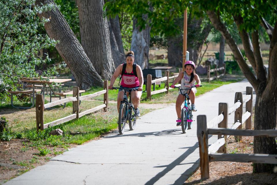 Nichole Romero, left, and Devyn Bobian, 10, ride bicycles along the trails of the Nature & Wildlife Discovery Center in May 2020.