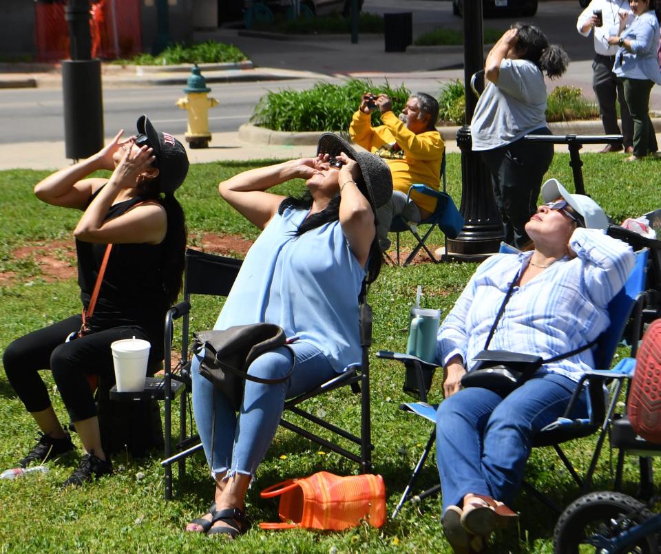 People use eclipse glasses to look up at the eclipse at Park Central in downtown Wichita Falls on Monday, April 8, 2024.