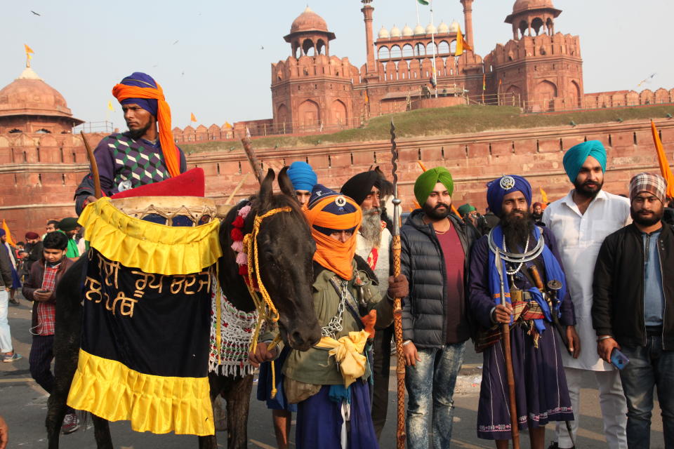 NEW DELHI, INDIA - JANUARY 26: Indian farmers gather at the iconic Red Fort during Republic Day to protest over new farming laws on January 26, 2021 in in New Delhi, India. Some farmers stormed the Red Fort and hoisted flags from the ramparts where traditionally India’s Prime Minister hoists the national flag on Independence Day. (Photo by Pallava Bagla/Corbis via Getty Images)