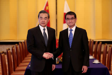 Chinese State Councilor and Foreign Minister Wang Yi (L) shakes hands with Japan's Foreign Minister Taro Kono at their meeting in Tokyo, Japan April 15, 2018. Behrouz Mehri/Pool via Reuters