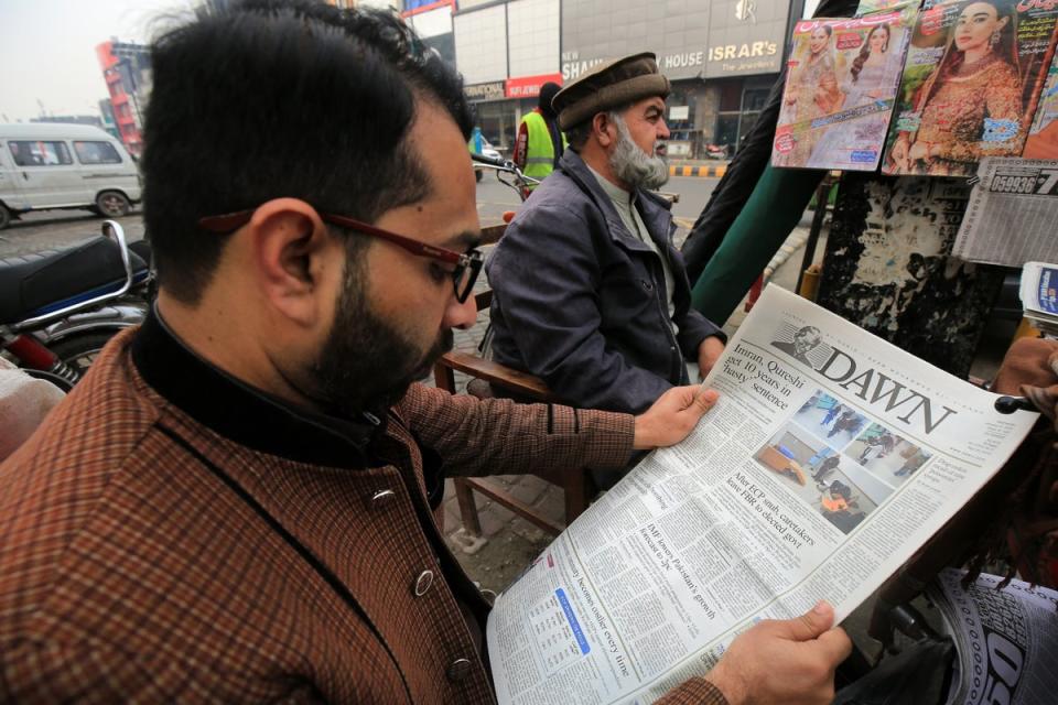 A man reads a newspaper reporting on the imprisonment sentence against former Prime Minister Imran Khan in Peshawar, (EPA)