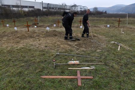 Gravediggers compete during a grave digging championship in Trencin, Slovakia, November 10, 2016, where eleven pairs of gravediggers are competing in digging based on accuracy, speed, and aesthetic quality. REUTERS/Radovan Stoklasa