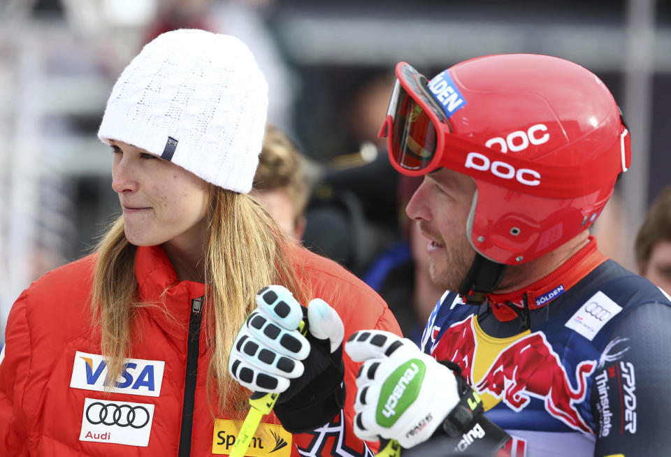 FILE - In this Jan. 23, 2014, file photo, Bode Miller talks to his wife, Morgan, in the finish area of men's skiing World Cup downhill training in Kitzbuehel, Austria. Miller is moving his family to Montana part time after a tumultuous year that included the tragic drowning of his toddler daughter. Miller says 19-month-old Emeline Miller's death made him sharpen his focus on his four other children, and with twins due this fall, he decided the time was right to head to the mountains. The family will split their time between homes in Southern California and Big Sky, Mont. (AP Photo/Giovanni Auletta, File)