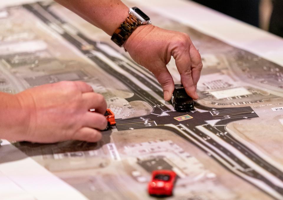 Nicole Minton uses toy cars to show how to navigate the changes to the Lloyd Expressway at Red Bank Road during a public hearing Tuesday, Sept. 26, 2023.