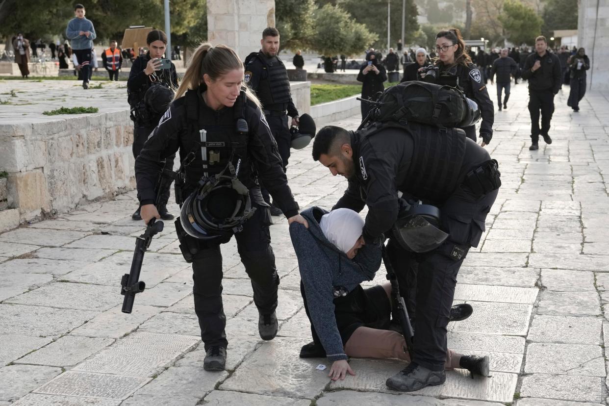 Israeli police arrest a Palestinian woman at the Al-Aqsa Mosque compound following a raid at the site in the Old City of Jerusalem during the Muslim holy month of Ramadan, Wednesday, April 5, 2023. Palestinian media reported police attacked Palestinian worshippers, raising fears of wider tension as Islamic and Jewish holidays overlap.
