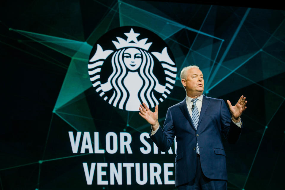 CEO Kevin Johnson speaks on a stage in front of the Starbucks logo and a sign saying Valor Siren Ventures.