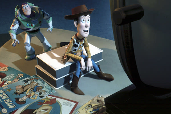Buzz Lightyear (voiced by Tim Allen) watches Woody (voiced by Tom Hanks) watching TV