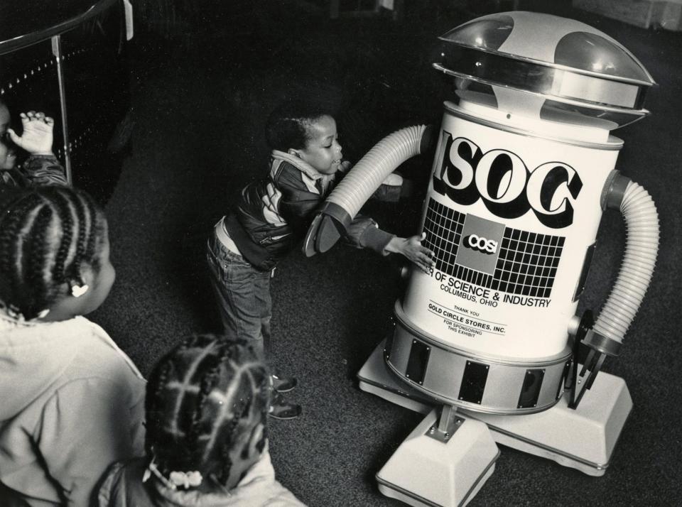1986 Richard Whiteside, 4, from John 23rd Head Start Fair Ave. Center gives ISOC the robot a hug at COSI.