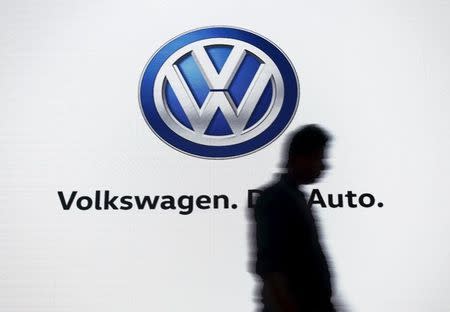 A man walks past a screen displaying a logo of Volkswagen at an event in New Delhi, India, June 23, 2015. REUTERS/Anindito Mukherjee/Files