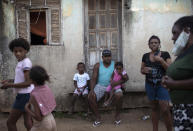 Residents of the Maria Joaquina "Quilombo" wait for the distribution of donated food, kits of cleaning products and protective face masks, amid the new coronavirus pandemic, in Cabo Frio, in the outskirts of Rio de Janeiro, Brazil, Sunday, July 12, 2020. The Maria Joaquina "Quilombo" is one of many Brazilian settlements comprised of descendants from runaway slaves. (AP Photo/Silvia Izquierdo)