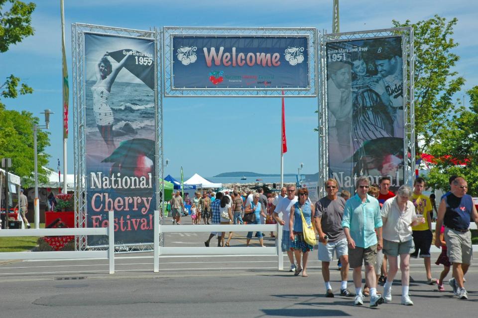 In this undated photo provided by the Traverse City Tourism, people enjoy a summer day in the Open Space park by Grand Traverse Bay in Traverse City, Mich. Some local residents say festivals occupy the park too much in summer, while others say it’s a reasonable price to pay for a strong tourism economy. (AP Photo/Traverse City Tourism)