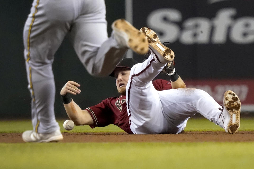 Arizona Diamondbacks second baseman Josh VanMeter, right, can't make a play on a base hit by Milwaukee Brewers' Jace Peterson as Kolten Wong advances to second during the sixth inning of a baseball game, Wednesday, June 23, 2021, in Phoenix. (AP Photo/Matt York)