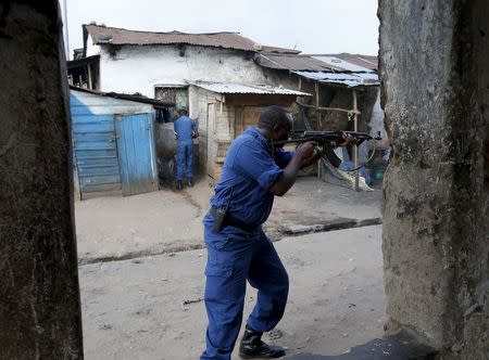 A policeman fires his AK- 47 rifle during a protest against Burundi President Pierre Nkurunziza and his bid for a third term in Bujumbura, Burundi, May 26, 2015. REUTERS/Goran Tomasevic