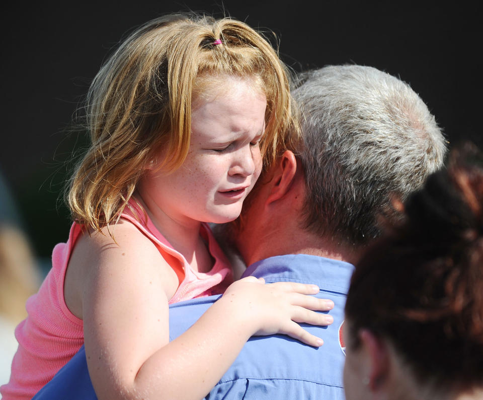 <p>Lilly Chapman, 8, cries after being reunited with her father, John Chapman at Oakdale Baptist Church on Wednesday, Sept. 28, 2016, in Townville, S.C. Students were evacuated to the church following a shooting at Townville Elementary School. A teenager opened fire at a South Carolina elementary school on Wednesday. (AP Photo/Rainier Ehrhardt) </p>