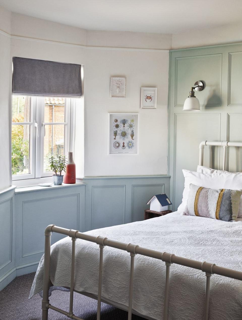 room with white iron bed and panelling