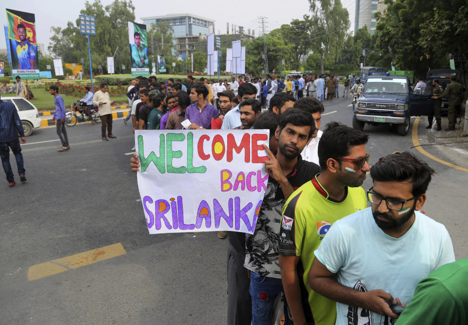 Cricket fans stand in queue for security check at Gaddafi stadium ahead of 1st Twenty20 match between Sri Lanka and Pakistan, in Lahore, Pakistan, Saturday, Oct. 5, 2019. Pakistan won the toss and elected to field in the first Twenty20 of the three-match series against inexperienced Sri Lanka. (AP Photo/K.M. Chaudary)