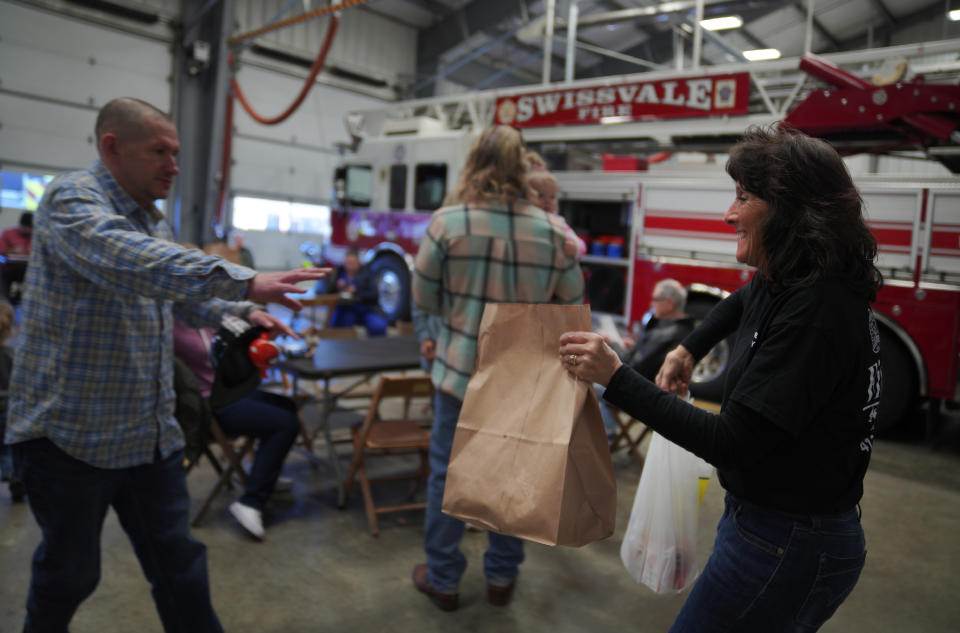 Jason Spade, left, takes his order from volunteer Diane Amos, at the Swissvale Fire Department fish fry in Pittsburgh, on Friday, Feb. 24, 2023. Fish fries have been a longtime Catholic tradition in Western Pennsylvania but increased in popularity in 1966 after the Second Vatican Council announced that not eating meat on Fridays was optional, except during Lent. Today they are held anywhere, from churches to fire stations to restaurants. (AP Photo/Jessie Wardarski)