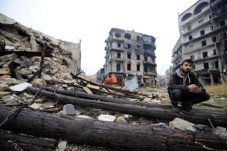 A man sits amid debris near Umayyad mosque, in the government-controlled area of Aleppo, during a media tour, Syria December 13, 2016. REUTERS/Omar Sanadiki