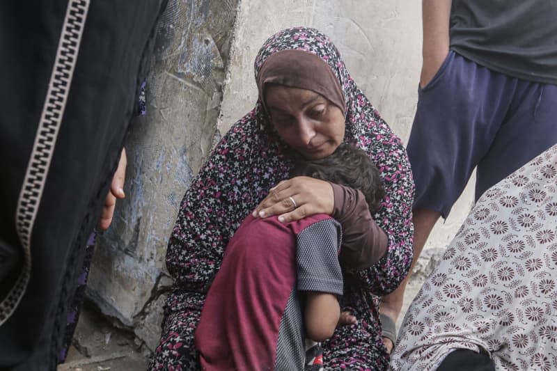 Relatives of Palestinian children who lost their lives as a result of an Israeli attack mourn as their bodies are taken to the morgue of Al-Aqsa Martyrs Hospital. Omar Ashtawy/APA Images via ZUMA Press Wire/dpa