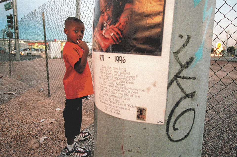 Kiondre Pollard, 6, stands next to a poster of Tupac Shakur before a vigil honoring the late hip-hop star on Sept. 13, 1996, in Las Vegas. Shakur’s shooting in a New York recording studio in the mid-1990s sparked hip-hop’s biggest rivalry and led to the shocking deaths of two of the genre's greatest stars, Shakur, in 1996, and Notorious B.I.G., six months later. Nearly three decades later, the recent arrest of longtime suspect Duane “Keffe D” Davis has ignited another wave of intrigue in their unsolved murders. (Mike Salsbury/Las Vegas Review-Journal via AP)