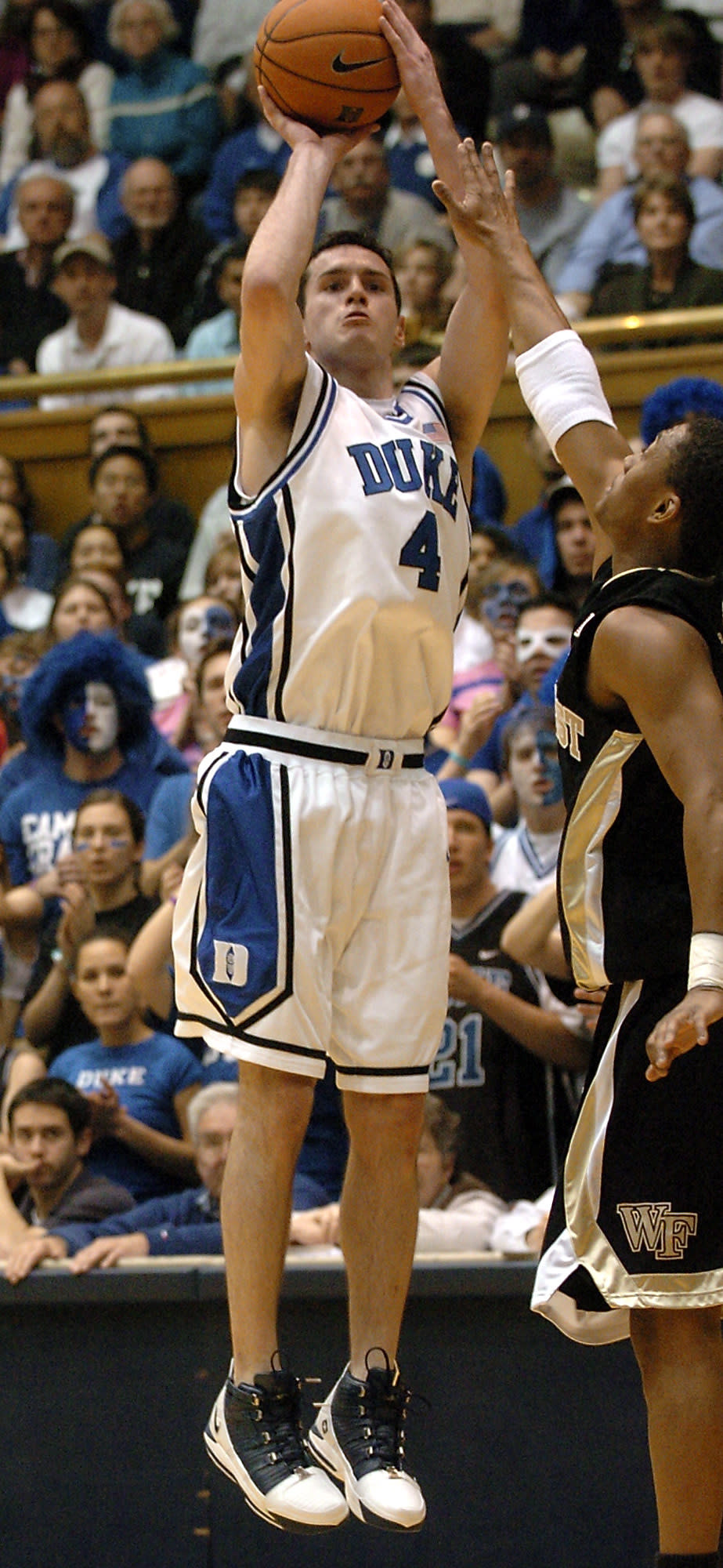 FILE - Duke's J.J. Redick (4) breaks the NCAA record for career high three-pointers made with 414 as he shoots over Wake Forest's Justin Gray, right, in the first half of a college basketball game in Durham, N.C., in this Tuesday, Feb. 14, 2006, file photo. Redick announced his retirement from basketball Tuesday, Sept. 21, 2021, ending a 15-season NBA career that came after he was the AP’s college player of the year at Duke in 2006. (AP Photo/Sara D. Davis, File)