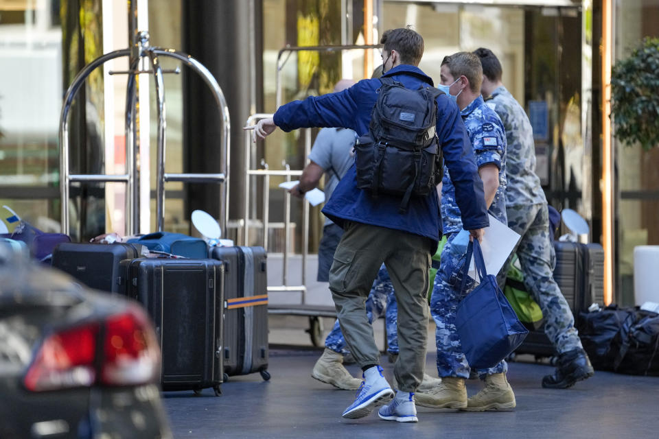 A traveler points to his luggage as he arrives at a quarantine hotel in Sydney, Australia, on May 20, 2021. New South Wales state, which includes Sydney, has announced it will end hotel quarantine requirements for fully-vaccinated international travelers from Nov. 1, 2021 in a major relaxation in pandemic restrictions. (AP Photo/Mark Baker)