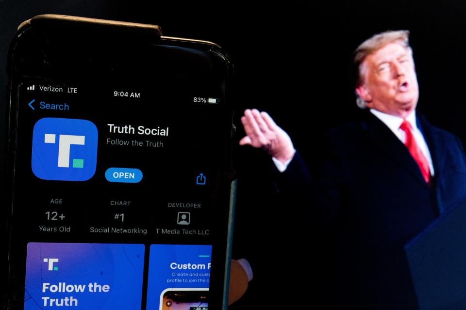 This photo illustration shows an image of former US President Donald Trump next to a phone screen that is displaying the Truth Social app, in Washington, DC, on February 21, 2022.