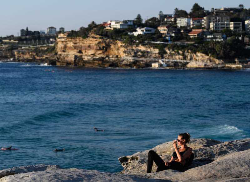 A woman looks out at the ocean near Bronte Beach in Sydney.