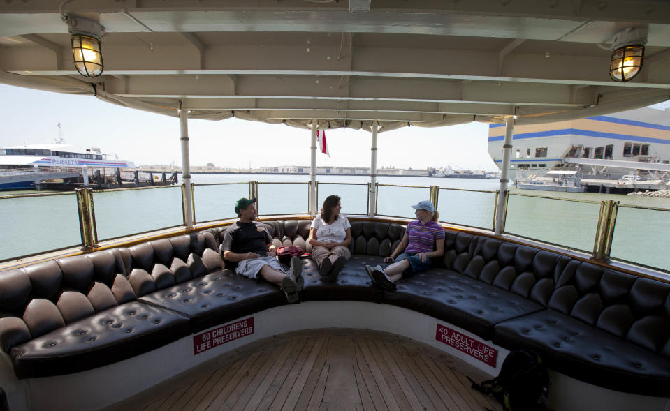 In this photo taken Wednesday July 4, 2012 people sit on the fantail of President Franklin D. Roosevelt's "Floating White House," the USS Potomac, at Jack London Square in Oakland, Calif. It’s not easy being Oakland. Growing up in the shadow of an icon is never a shoe-in, whether you’re a wannabe princess related to that attention-grabbing vamp Cinderella or a city living next door to fabled San Francisco. (AP Photo/Eric Risberg)