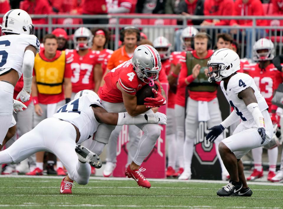 Oct 21, 2023; Columbus, Ohio, USA; Ohio State Buckeyes wide receiver Julian Fleming (4) makes a catch against Penn State Nittany Lions linebacker Kobe King (41) during the third quarter of their game at Ohio Stadium.