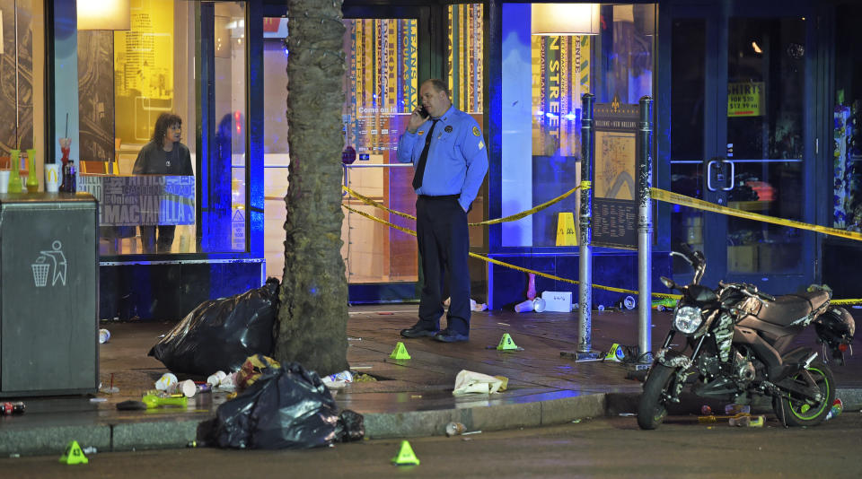 A woman looks out from inside a McDonald's fast food restaurant as New Orleans police investigate the scene of a shooting Sunday, Dec. 1, 2019, on the edge of the city's famed French Quarter. (Max Becherer/The Times-Picayune/The New Orleans Advocate via AP)