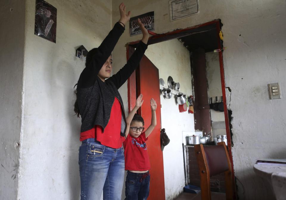 Marlene Beltrán, de 14 años (izq) y su hermano Fellipe, de cinco, hacen ejercicios durante una clase de gimnasia impartida a través de la radio Bacata Stereo durante el confinamiento del coronavirus en Funza, Colombia, el 13 de mayo del 2020. (AP Photo/Fernando Vergara)