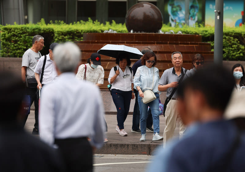 鋒面影響  西半部留意局部大雨（1） 中央氣象署表示，23日鋒面影響，各地降雨機率高， 容易出現短暫陣雨或雷雨，西半部地區有局部大雨， 東北部地區有較大雨勢發生的機率。台北市信義區下 午1時左右沒有雨勢，民眾撐傘遮陽。 中央社記者張新偉攝  113年4月23日 