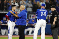 Toronto Blue Jays' Whit Merrifield, left, is checked on by medical staff after being hit by a pitch by Seattle Mariners relief pitcher Diego Castillo during the fifth inning of Game 2 of a baseball AL wild-card playoff series Saturday, Oct. 8, 2022, in Toronto. (Frank Gunn/The Canadian Press via AP)