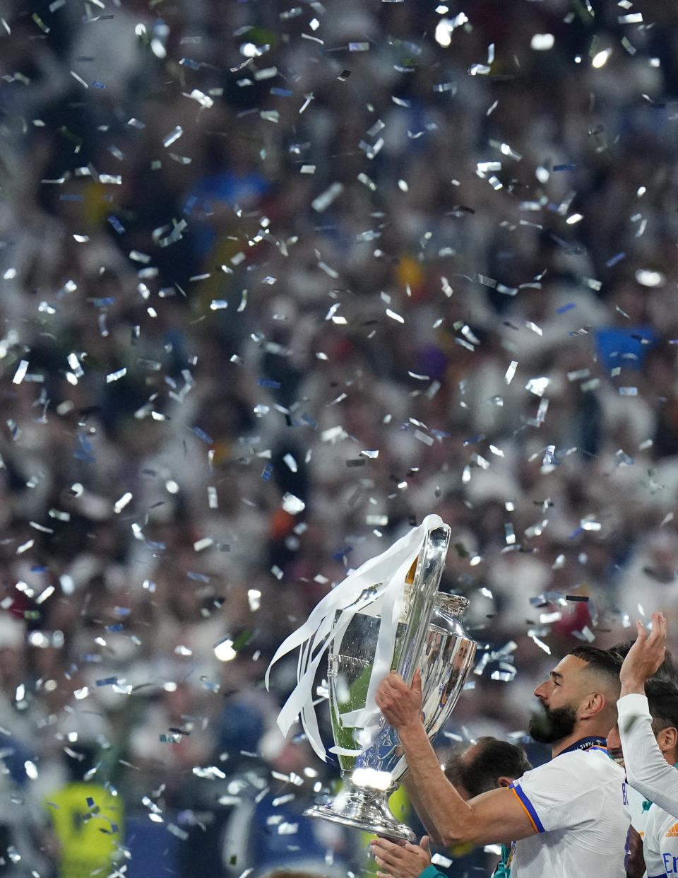 Real Madrid's Karim Benzema holds the trophy after the Champions League final soccer match between Liverpool and Real Madrid at the Stade de France in Saint Denis near Paris, Saturday, May 28, 2022. Real won 1-0. (AP Photo/Petr David Josek)