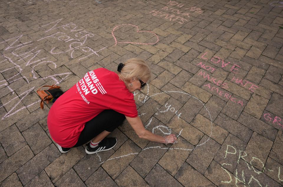 Jeannie Williamson writes messages in chalk outside the Governor's Mansion.