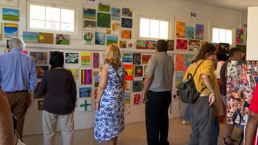Guests look at some of roughly 300 paintings done by local homeless artists. (Olivia Yepez)