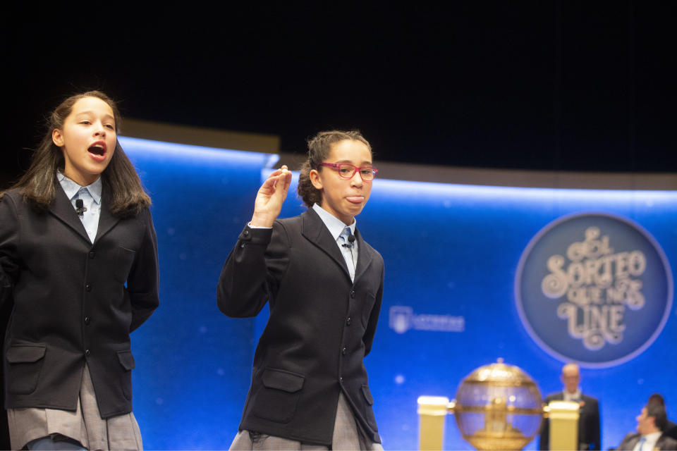 Children from Madrid's San Ildefonso school call out the winning lottery ticket number at Madrid's Teatro Real opera house during Spain's bumper Christmas lottery draw in Madrid, Spain, Sunday, Dec. 22, 2019. The lottery, known as El Gordo, or The Fat One, will dish out 2.24 billion euros ($2.43 billion) in prizes. (AP Photo/Paul White)