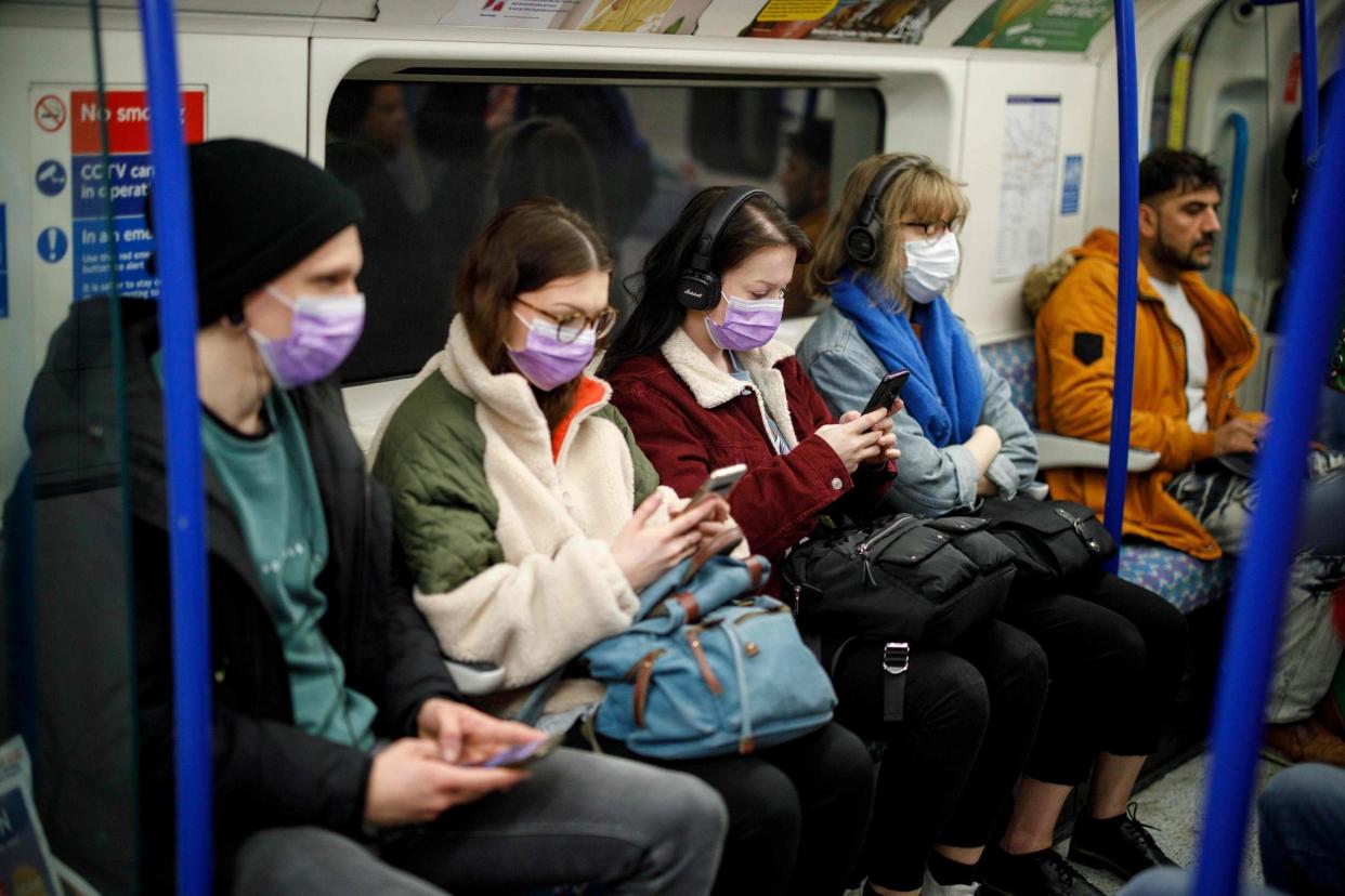 Commuters wear masks as a precaution whilst travelling on a London Underground Tube train on Wednesday: AFP via Getty Images