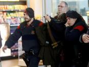 Family members of passengers killed in Germanwings plane crash are escorted by Regional Catalan Police officers as they arrive at Barcelona's El Prat airport March 24, 2015. REUTERS/Albert Gea