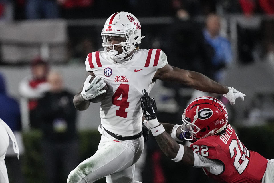 Mississippi running back Quinshon Judkins (4) tries to escape from Georgia defensive back Javon Bullard (22) during the first half of an NCAA college football game, Saturday, Nov. 11, 2023, in Athens, Ga. (AP Photo/John Bazemore)