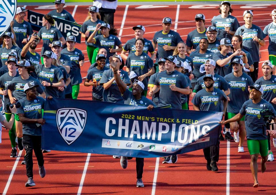 Members of the Oregon Track Team run a ceremonial lap after winning the men's and women's Pac-12 Track and Field Championships at Hayward Field Sunday.