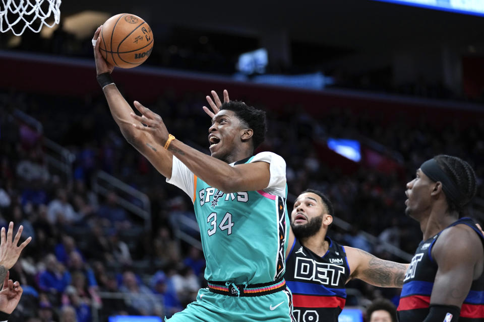 San Antonio Spurs forward Stanley Johnson (34) drives on Detroit Pistons guard Cory Joseph (18) in the second half of an NBA basketball game in Detroit, Friday, Feb. 10, 2023. (AP Photo/Paul Sancya)