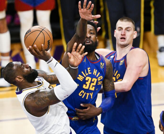 LOS ANGELES, CA - MAY 20: Los Angeles Lakers forward LeBron James, left, is fouled by Denver Nuggets forward Jeff Green on a shot attempt during the fourth quarter of game three in the NBA Playoffs Western Conference Finals at Crypto.com Arena on Sunday, May 20, 2023 in Los Angeles, CA. (Gina Ferazzi / Los Angeles Times)