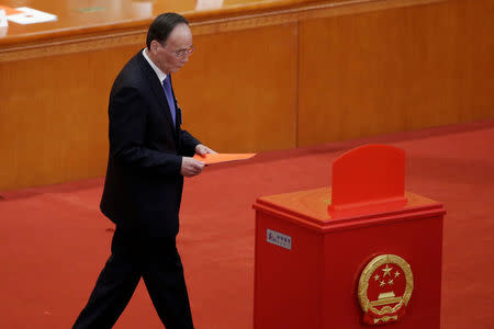 Wang Qishan, former secretary of the Central Commission for Discipline Inspection, walks with his ballot before a vote at the fifth plenary session of the National People's Congress (NPC) at the Great Hall of the People in Beijing, China March 17, 2018. REUTERS/Jason Lee