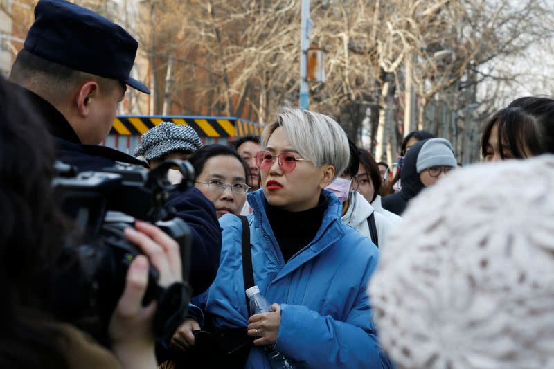 Teresa Xu speaks to a police officer outside Chaoyang People's Court after a court hearing in Beijing